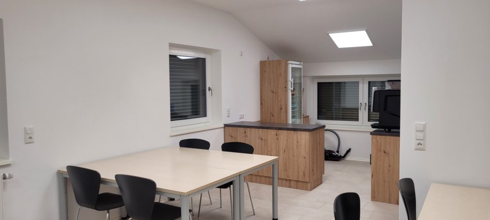 Helle, moderne Küche mit Tisch, Stühlen und Holzschränken.